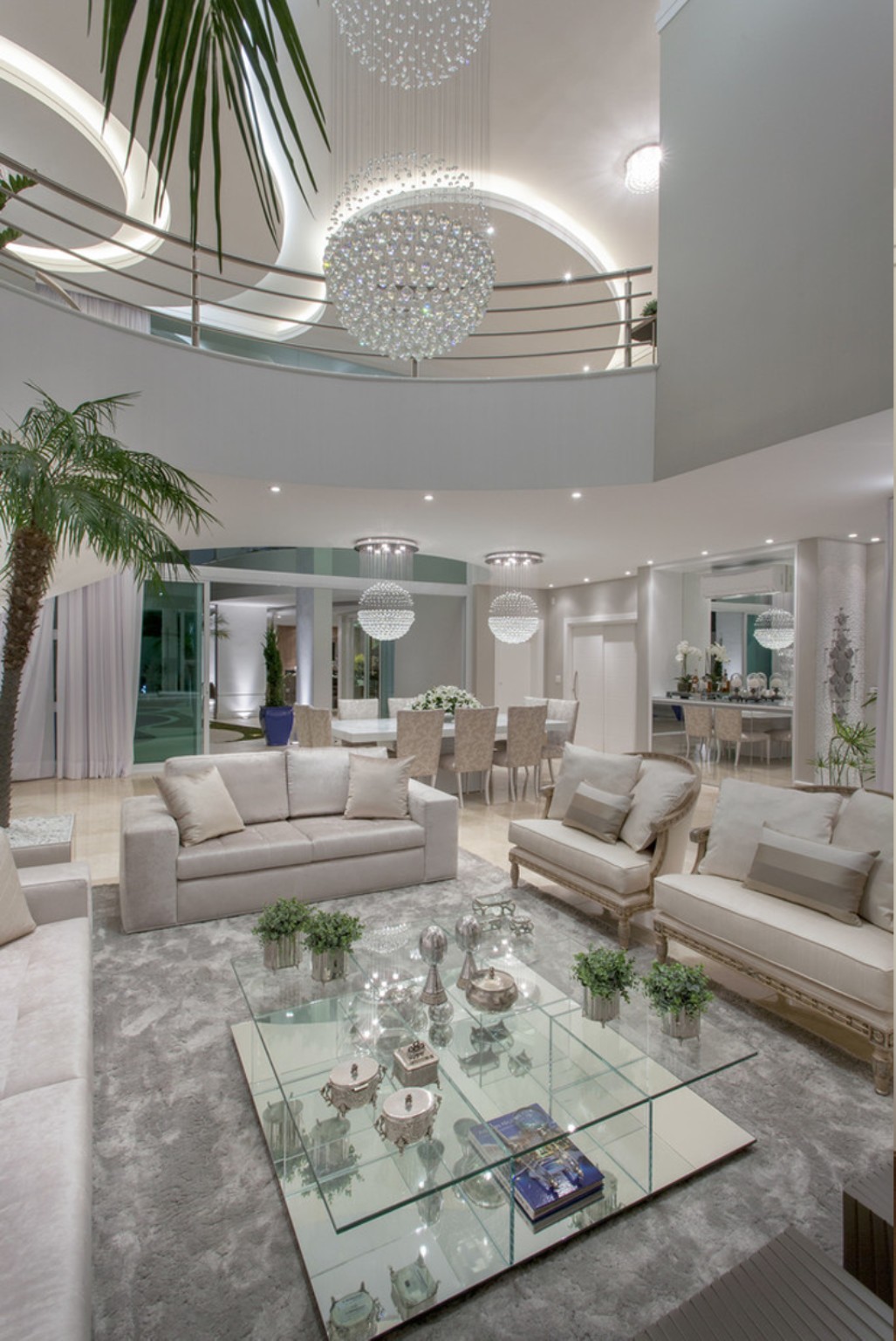 Ambiente branco amplo com lustre e iluminação artificial intensa